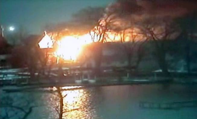 This image taken from video provided by WHAM13-TV, shows a wide view of homes on fire in an area where a gunman ambushed four volunteer firefighters responding to an intense pre-dawn house fire early Monday, Dec. 24, 2012, in Webster, N.Y., killing two before ending up dead himself, authorities said. Police used an armored vehicle to evacuate more than 30 nearby residents. 