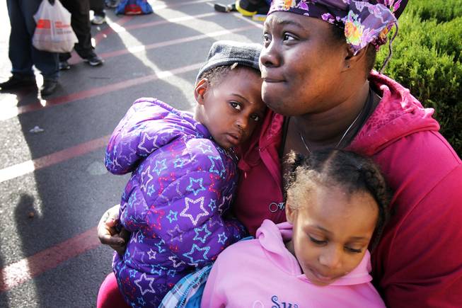Evelyn (who lives at Shade Tree Shelter and did not want her and her daughters last names used) waits in line with her daughters Jazmine, left, 2, and Pasha-e, 5, during a Christmas Day event to feed and clothe the homeless and needy organized by the nonprofit organization Broken Chains in Las Vegas on Tuesday, December 25, 2012.