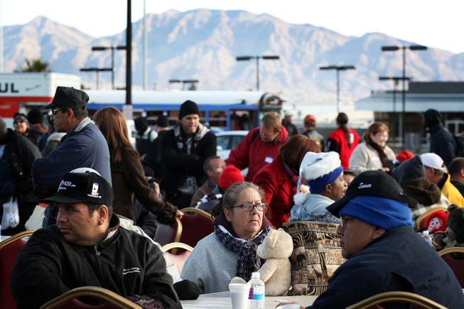 People gather at tables to dine during a Christmas Day event to feed and clothe the homeless and needy organized by the nonprofit organization Broken Chains in Las Vegas on Tuesday, December 25, 2012.