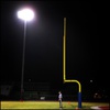 A referee waits in the end zone during a high school football game.