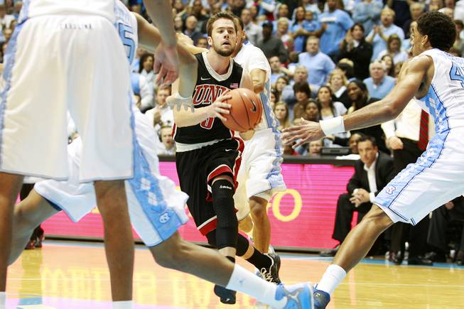 Surrounded by North Carolina players, UNLV guard Katin Reinhardt looks for an open teammate during their game Saturday, Dec. 29, 2012 at the Dean Smith Center in Chapel Hill, N.C. North Carolina won the game 79-73.