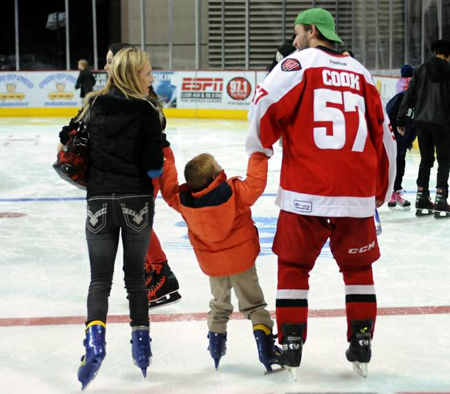 Las Vegas Wranglers defenseman Charlie Cook helps a young fan skate along the ice at the Orleans Arena as the team invited fans to join the players on the ice after the game on Dec. 31, 2012.