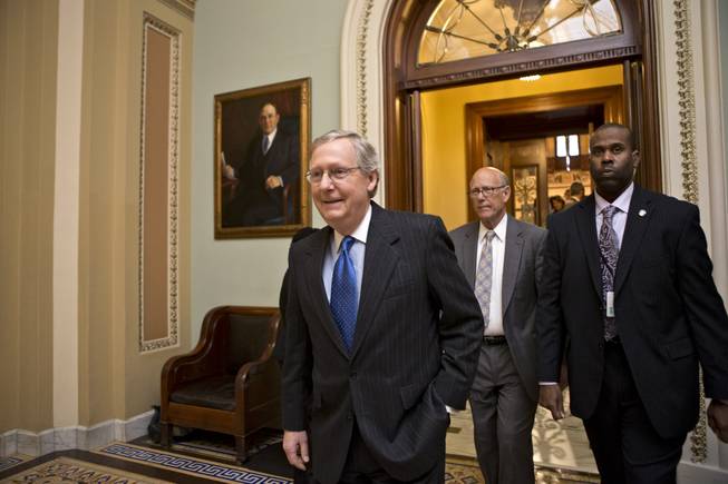 Senate Minority Leader Mitch McConnell, R-Ky., followed by Sen. Pat Roberts, R-Kan., second from right, leaves the Senate chamber to meet with fellow Republicans in a closed-door session as the "fiscal cliff" negotiations continue at the Capitol in Washington, Sunday, Dec. 30, 2012.