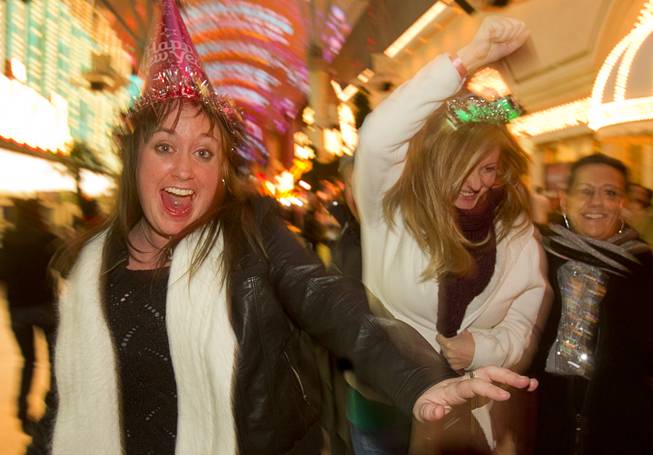 Ashley Smith, left, and Erica Forsstrom of Las Vegas dance during the New Years Eve party at the Fremont Street Experience Monday, Dec. 31, 2012.
