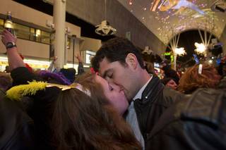 Danielle Weber and Troy Nuccio of Detroit kiss just after midnight fireworks just before midnight during the New Years Eve party at the Fremont Street Experience Tuesday, Jan.1, 2013.