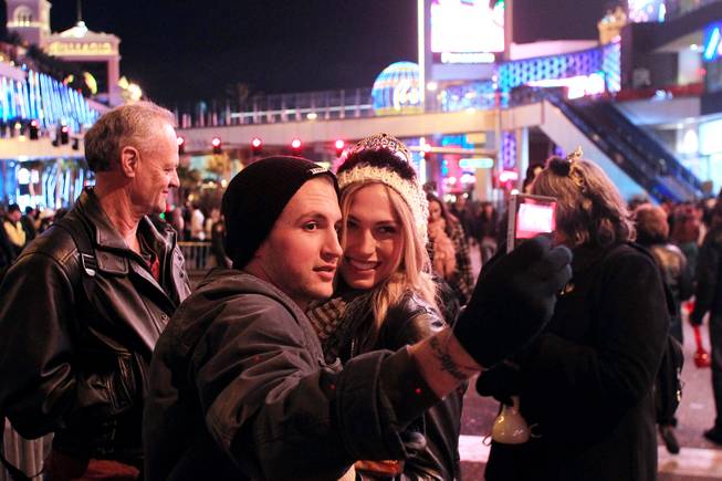 Zach Thompson and Kelli Schuh, both from Fresno, Calif., take a photo during the New Year's Eve celebration on the Strip Monday, Dec. 31, 2012.