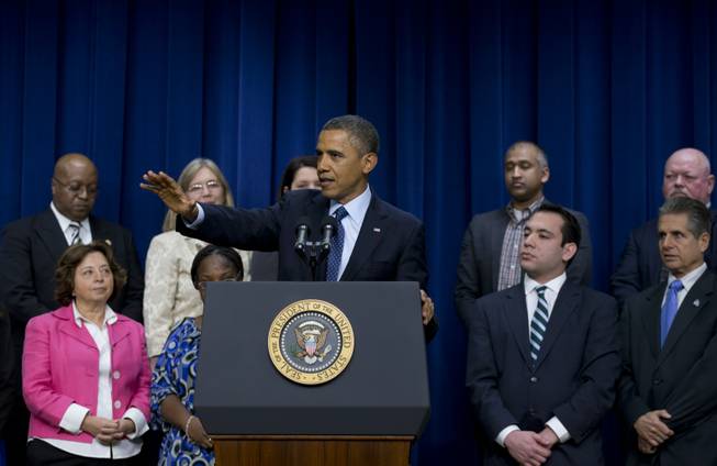 People stand behind President Barack Obama as he speaks about the fiscal cliff in the South Court Auditorium in the Eisenhower Executive Office Building of the White House complex, Monday, Dec. 31, 2012, in Washington. 