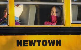 A girl sits on a Newtown bus leaving the new Sandy Hook Elementary School after the first day of classes in Monroe, Conn., Thursday, Jan. 3, 2013.  The Sandy Hook students started today in a new school, formerly called Chalk Hill School in Monroe.  It was renamed Sandy Hook Elementary and overhauled especially for the students from the Sandy Hook School shooting. 