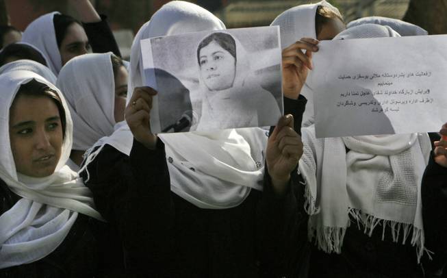 In this Saturday, Oct 13, 2012 photo, Afghan students express their support for Pakistani schoolgirl Malala Yousafzai outside their school in Herat, Afghanistan. 