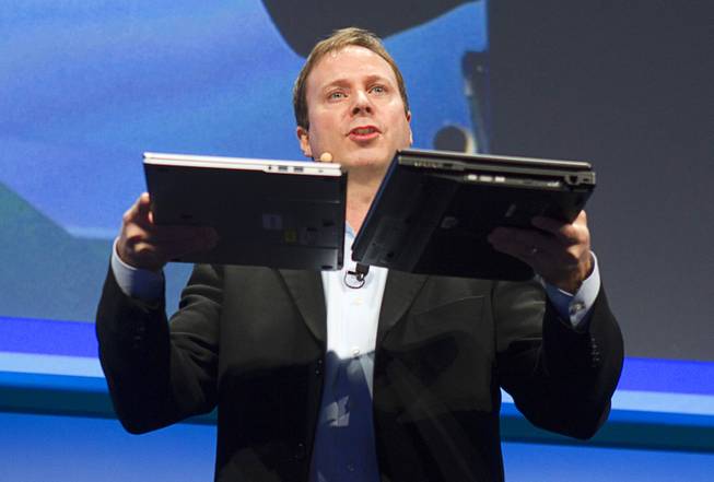Kirk Skaugen, Intel's vice president of PC client group, compares the thickness of a new NEC Ultrabook (12.8mm thick) and a three-year-old laptop at an Intel press conference during the 2013 International CES in the Mandalay Bay Convention Center Monday, January 7, 2013. Intel announced improvements to its processors including one with "all day" battery life. Intel also announced the availability of live and on-demand pay TV content to Intel devices.