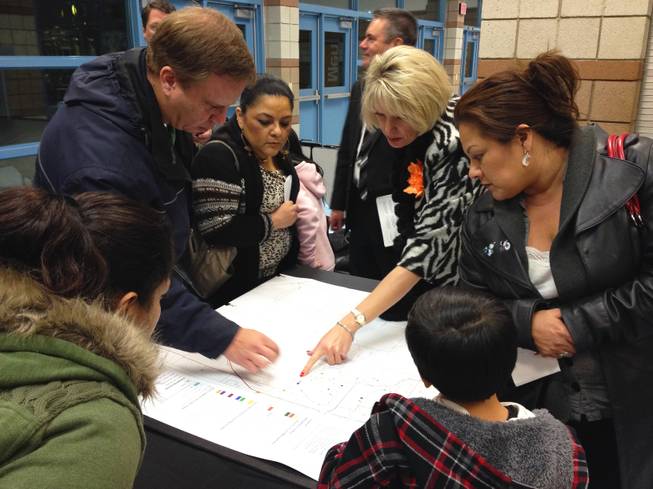 Southwest valley parents look over a school attendance zone map at Sierra Vista High School on Monday, Jan. 7, 2013. The Clark County School District held a town hall-style meeting to discuss solutions to school overcrowding, including major rezoning and reverting to an year-round schedule. 