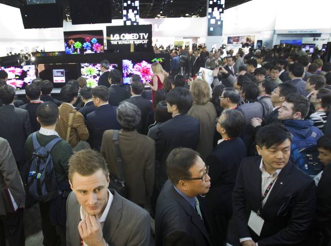 Attendees crowd displays in the LG Electronics booth during the first day of the 2013 International CES in the Las Vegas Convention Center Tuesday, Jan. 8, 2013. 