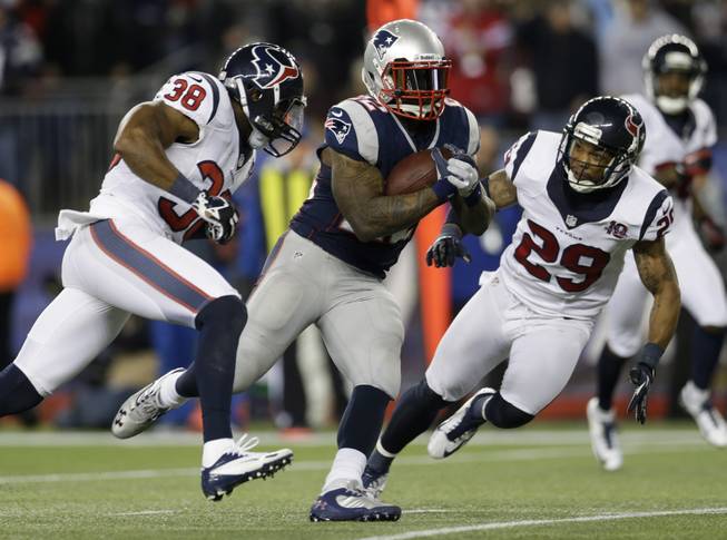 New England Patriots running back Stevan Ridley runs past Houston Texans safeties Danieal Manning (38) and Glover Quin as he scores on an eight-yard touchdown run during the second half of an AFC divisional playoff NFL football game in Foxborough, Mass., Sunday, Jan. 13, 2013.