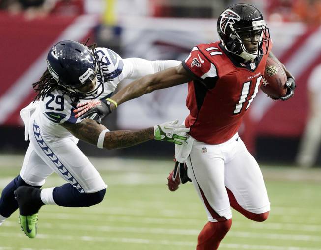 Atlanta Falcons wide receiver Julio Jones (11) tries to get away from Seattle Seahawks' Earl Thomas (29) during the first half of an NFC divisional playoff NFL football game Sunday, Jan. 13, 2013, in Atlanta. 