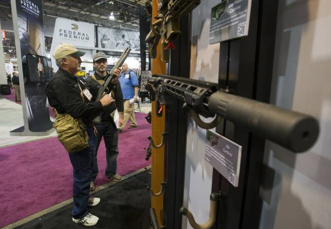 John Chadwick, left, and his son Joshua, of Triple J Firearms in Magnolia, Texas, look over Remington rifles and shotguns during the annual SHOT (Shooting, Hunting, Outdoor Trade) Show in the Sands Expo Center Tuesday, Jan. 15, 2013. Gun dealers at the show are reporting booming sales resulting from worries about possible gun control legislation. STEVE MARCUS