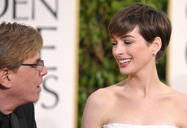 Aaron Sorkin, left, and Anne Hathaway arrive at the 70th Annual Golden Globe Awards at the Beverly Hilton Hotel on Sunday Jan. 13, 2013, in Beverly Hills, Calif. 