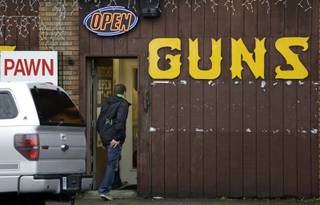 A man walks into a gun shop Wednesday, Dec. 19, 2012, in Seattle. The reaction to the Connecticut school shooting can be seen in gun stores and self-defense retailers across the nation: Anxious parents are fueling sales of armored backpacks for children while firearms enthusiasts are stocking up on assault rifles in anticipation of tighter gun control measures. 