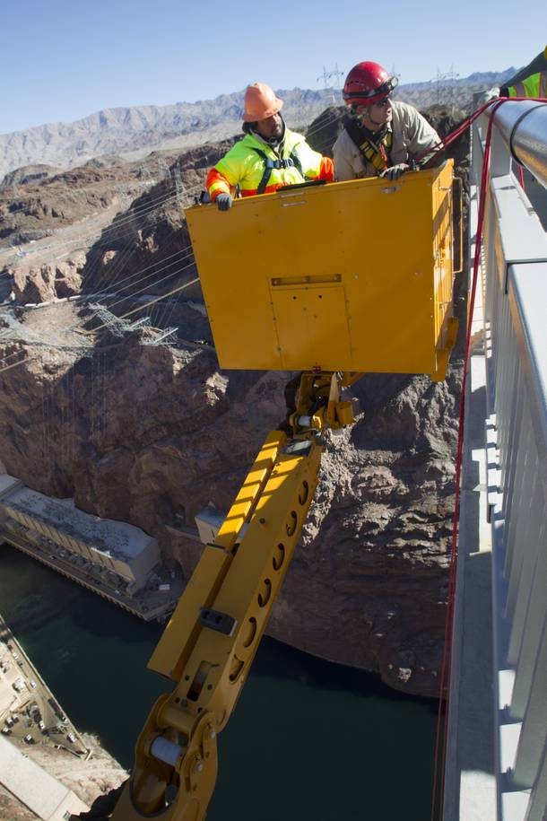 Myron Marr, a Nevada Department of Transportation bucket operator, left, and Matt Bialowas, a Stantec engineer/inspector, come up to a walkway during a safety inspection of the Mike O'Callaghan-Pat Tillman Memorial Bridge Wednesday, January 16, 2013.