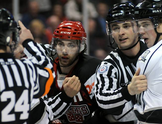 Wrangler defenseman Jamie Fritsch (center) listens as ECHL referee Andrew Wilk (left) asesses penalties to Fritsch and Colorado player Collin Bowman (right) after a small second period skirmish on Saturday night. Restraining Bowman at right is ECHL linesman Brett Martin.