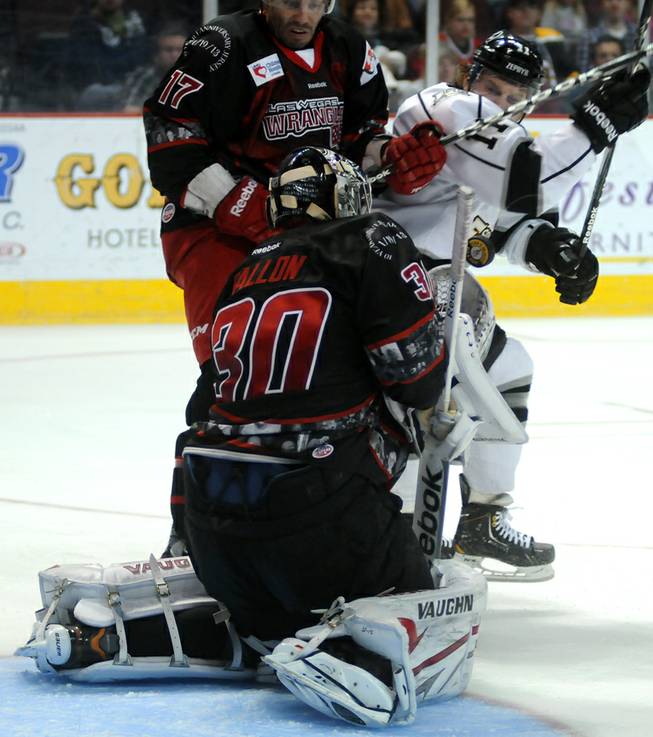 Adam Huxley, left, battles for position against Norm Ezekiel as Wrangler goaltender Joe Fallon squares up to stop a Colorado shot during the second period of play at the Orleans Arena on Saturday night.