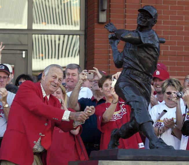In this Oct. 1, 2006, file photo, St. Louis Cardinals great Stan "The Man" Musial strikes his signature pose after unveiling his statue at the re-dedication ceremony for the statues, at the new Busch Stadium, of Cardinals Hall of Famers and notables. Musial, one of baseball's greatest hitters, died Saturday, Jan 19, 2012, the Cardinals announced. He was 92.