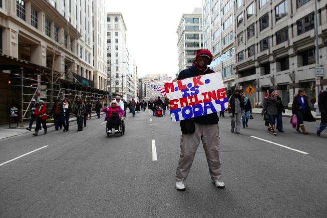 Roderick Beechum of Virgina displays a sign while walking down H Street NW in Washington, D.C., a few blocks away from the National Mall on Inauguration Day, Monday, Jan. 21, 2013.