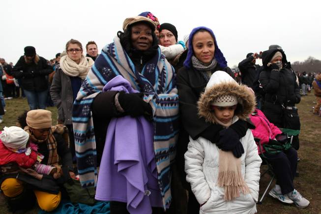 From left to right, Kimberly Graham of Jersey City, New Jersey and Natasha Bennett of New York watch the presidential inauguration ceremony on the National Mall in Washington, D.C., Monday, Jan. 2013.
