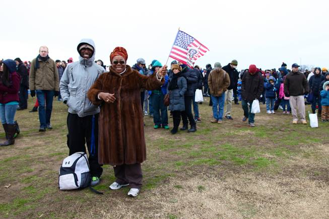 Lynnette Lynn-Horton of Capitol Heights, joined by her son Jordan Coleman, waves an American flag with Barack Obama's likeness on it while watching the presidential inauguration on the National Mall Monday, Jan. 21, 2013.