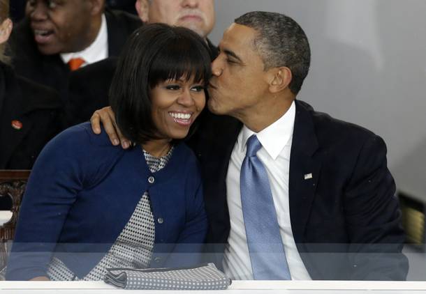 President Barack Obama kisses first lady Michelle Obama in the presidential box near the White House, Monday, Jan. 21, 2013, in Washington. Thousands  marched during the 57th Presidential Inauguration parade after the ceremonial swearing-in of President Barack Obama. 