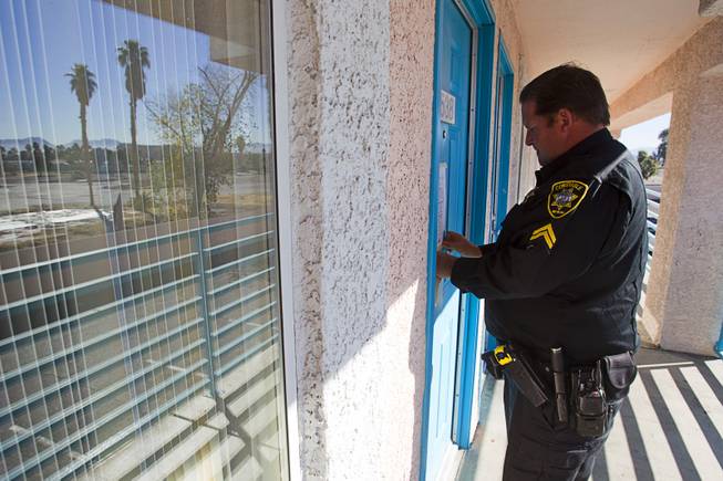 Deputy Constable Patrick Geary tapes a 24-hour eviction notice on the door of an apartment in the southwest Las Vegas Valley on Tuesday, Jan. 22, 2013. Apartment managers can post the notice themselves but often hire a constable.