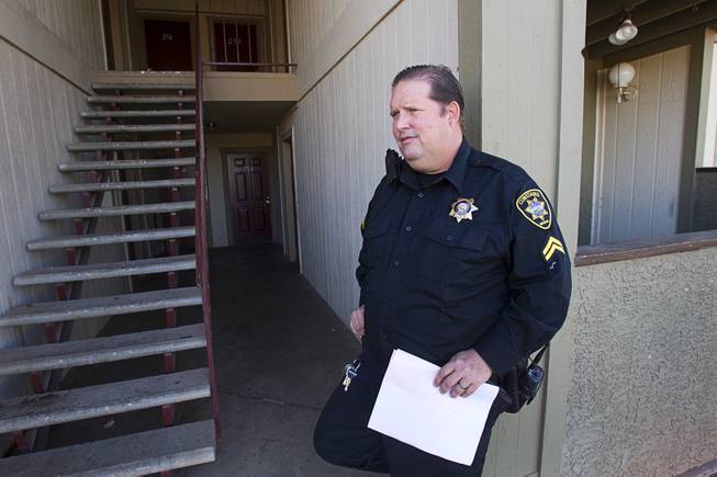 Deputy Constable Patrick Geary waits for a maintenance worker to change the locks of an apartment during an eviction in the southwest part of the Las Vegas Valley Tuesday, Jan. 22, 2013. The resident had already moved out.