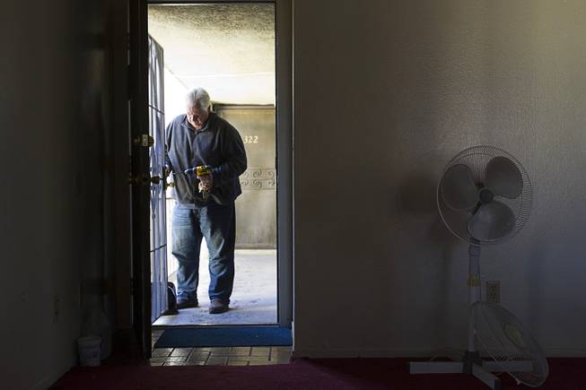 Joe Ingersoll, of All American Locksmiths, changes the lock on a security door during an eviction in the southwest part of the Las Vegas Valley Tuesday, Jan. 22, 2013.