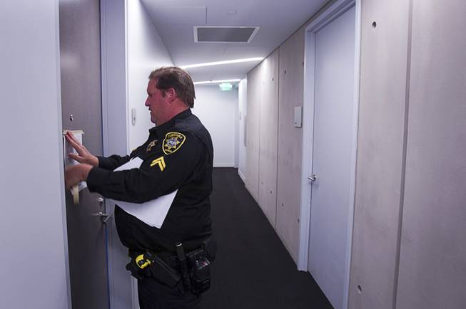 Deputy Constable Patrick Geary posts an eviction notice on a door of a condo in the Veer Towers Tuesday, Jan. 22, 2013.