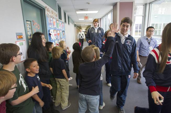 Students give high fives to Coronado High School basketball players and cheerleaders as the high schoolers arrive to mentor first- and second-graders at Glen Taylor Elementary School in Henderson on Wednesday, Jan. 23, 2013.
