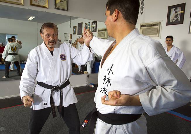 Karate master Dan Sawyer, left, demonstrates a technique with instructor Andy Dowdell, a fifth degree black belt, during a class at his home Sunday, Jan. 27, 2013. Sawyer teaches in a garage behind his home that has been converted into a karate dojo.