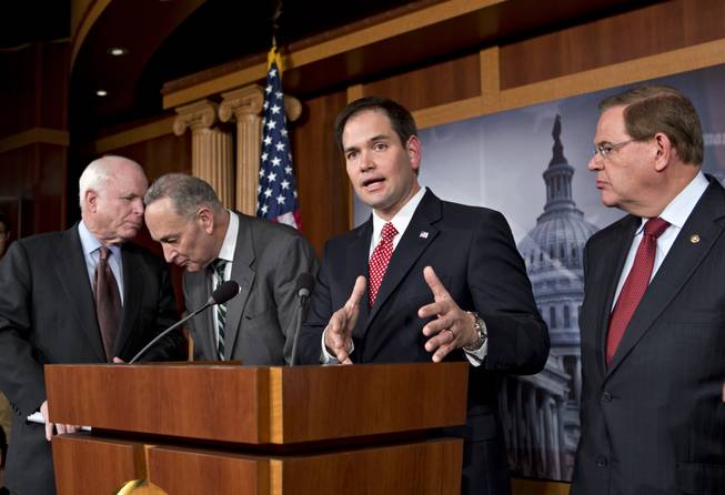 Sen. Marco Rubio, R-Fla.. center, answers a reporter's question as a bipartisan group of leading senators and he announce that they have reached agreement on the principles of sweeping legislation to rewrite the nation's immigration laws during a news conference at the Capitol in Washington, D.C., on Monday, Jan. 28, 2013. From left are Sen. John McCain, R-Ariz., Sen. Charles Schumer, D-N.Y., Rubio and Sen. Robert Menendez, D-N.J.
