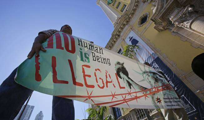 Immigration reform activists hold a sign in front of Freedom Tower in downtown Miami, Monday, Jan. 28, 2013.  