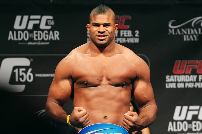 Alistair Overeem flexes on the scale during weigh ins for UFC 156 Friday, Feb. 1, 2013.