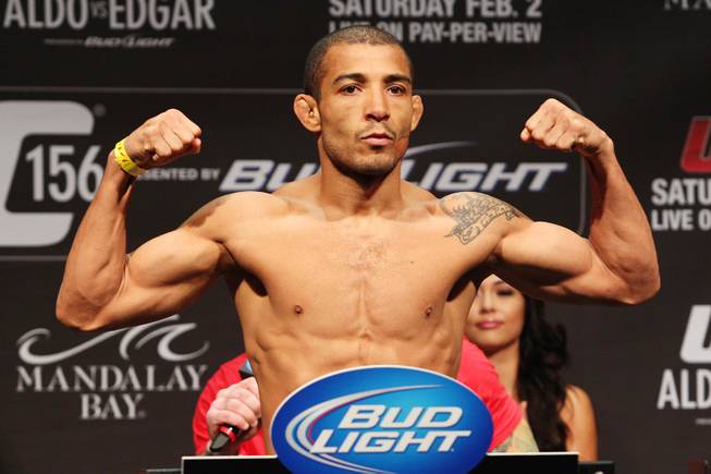 Jose Aldo flexes on the scale during weigh ins for UFC 156 Friday, Feb. 1, 2013.