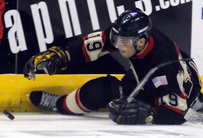 Las Vegas Valley fire player Kevin Fourman reaches for a fluttering puck after losing an edge near the boards during the second period of the Guns and Hoses Winter Classic 2013 on Saturday afternoon at the Orleans Arena.