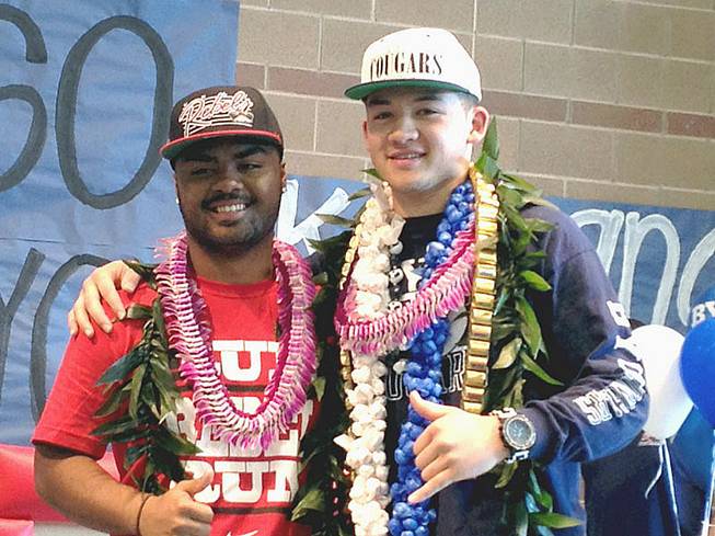 Liberty football players Niko Kapeli, left, and Kai Nacua are shown together after signing national letters of intent Wednesday, Feb. 6, in their school's gymnasium. 