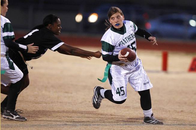 Palo Verde quarterback Kaitlyn Millican scrambles out of the reach of Silverado's Daiva Kempfer during the district championship for flag football Wednesday, Feb. 13, 2013. Palo Verde won the game 7-6.