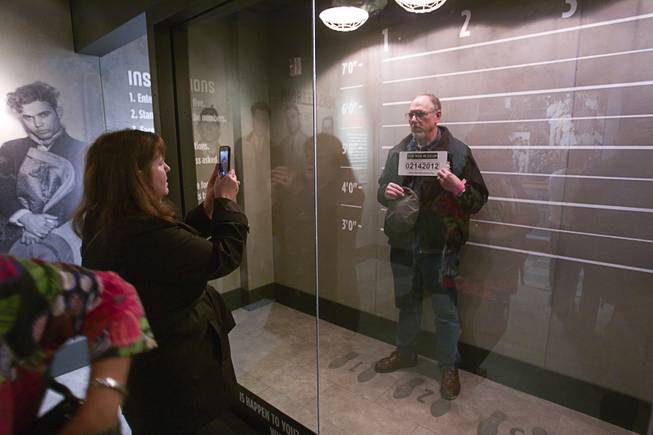 Patricia Brown of Anchorage, Alaska takes a photo of her husband Dave McMahan at the Mob Museum, the National Museum of Organized Crime and Law Enforcement, in downtown Las Vegas Wednesday, Feb.13, 2013. The museum celebrates it's first anniversary on Valentine's Day.