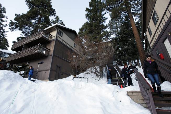 Members of the media are shown outside a home, at left, in Big Bear, Calif., where two women were taken hostage by fugitive Christopher Dorner. Police scoured mountain peaks for days using everything from bloodhounds to high-tech helicopters in their manhunt for Dorner, a revenge-seeking ex-cop. They had no idea he was hiding among them, possibly holed up in this vacation home across the street from their command post.