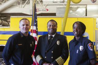 Newly promoted Fire Captain Darren Morville, left, and Fire Engineer Jennifer Osborne, right, pose for a picture with Clark County Fire Chief Bertral Washington after a ceremony honoring Osborne, Friday, Feb. 15, 2013. Osborne is the first black female to be promoted to Fire Engineer in the Clark County Fire Department.