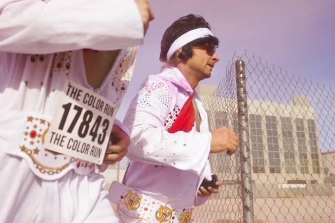 Two participants dressed as Elvis round the corner after passing the pink stage of the 5K Color Run, Saturday, Feb. 16, 2013. 