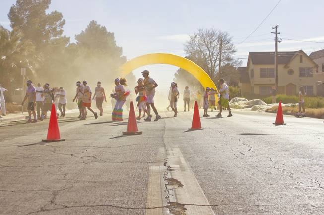 Participants come out of a yellow haze as they pass through the yellow stage of the 5K Color Run, Saturday, Feb. 16, 2013. 