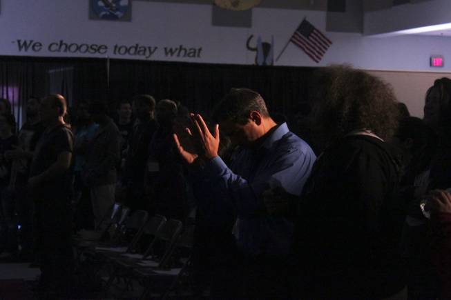 An attendee raises his hands in prayer during the Grace City Church service, Sunday, Feb. 17, 2013. The new Las Vegas church rents out the Jack Schofield Middle School auditorium as a temporary venue to hold their Sunday service.