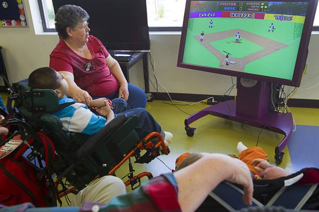 A student uses a pressure pad to play a baseball video game at the new John F. Miller School, a school which serves students with disabilities and special needs, Wednesday Feb. 20, 2013. The school has been nominated for a national design award.