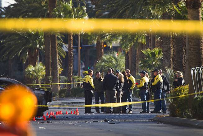Investigators confer at the site of a shooting and multi-car accident that left three people dead and at least three injured on the Las Vegas Strip early Thursday morning, Feb. 21, 2013.